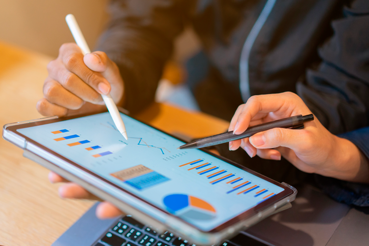 Pessoas a utilizar um tablet com métricas a monitorizar para melhorar os resultados nas redes sociais